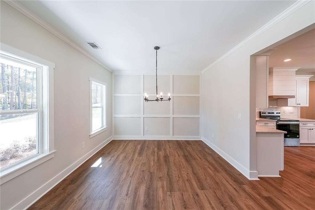 3300 Holly Springs Road Rockmart, GA 30153 - Photo 5 of 38 a view of empty room with wooden floor and kitchen view