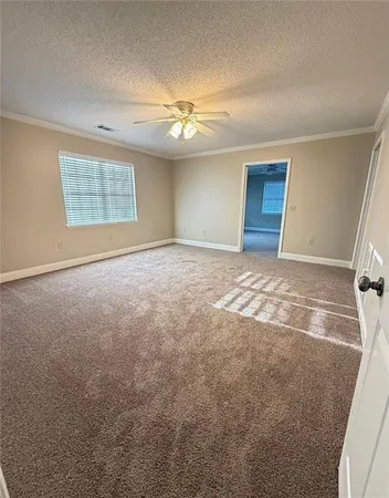 an empty room with windows and fan