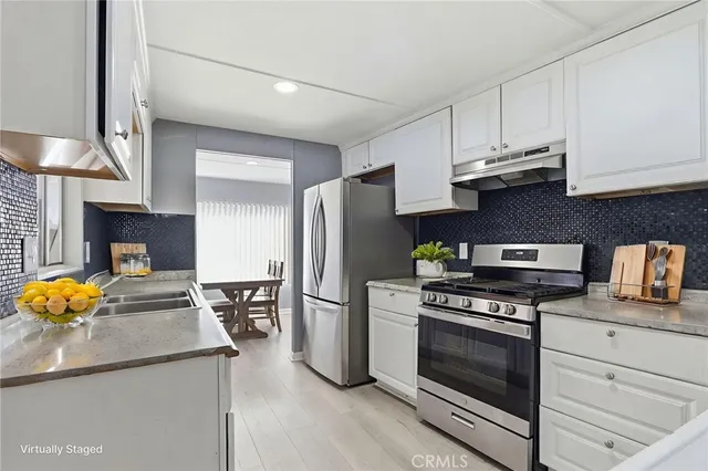 a kitchen with stainless steel appliances granite countertop a stove a refrigerator and a stove