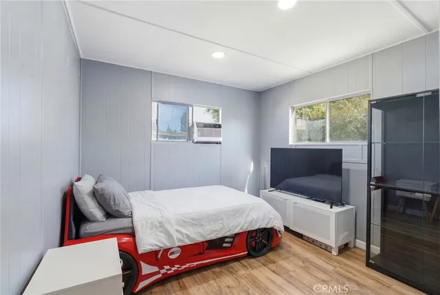 a bedroom with a bed and a flat screen tv