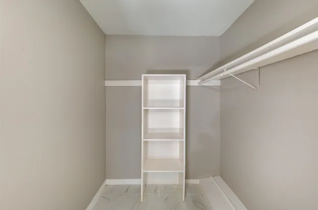 a view of walk in closet with empty racks