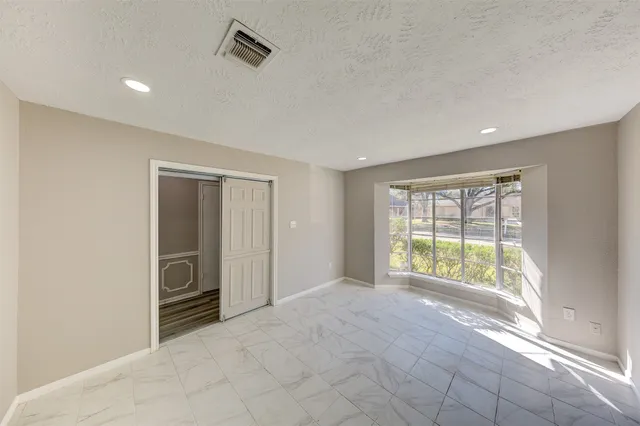 an empty room with windows and closet