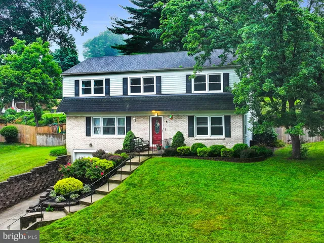a front view of a house with a yard and trees