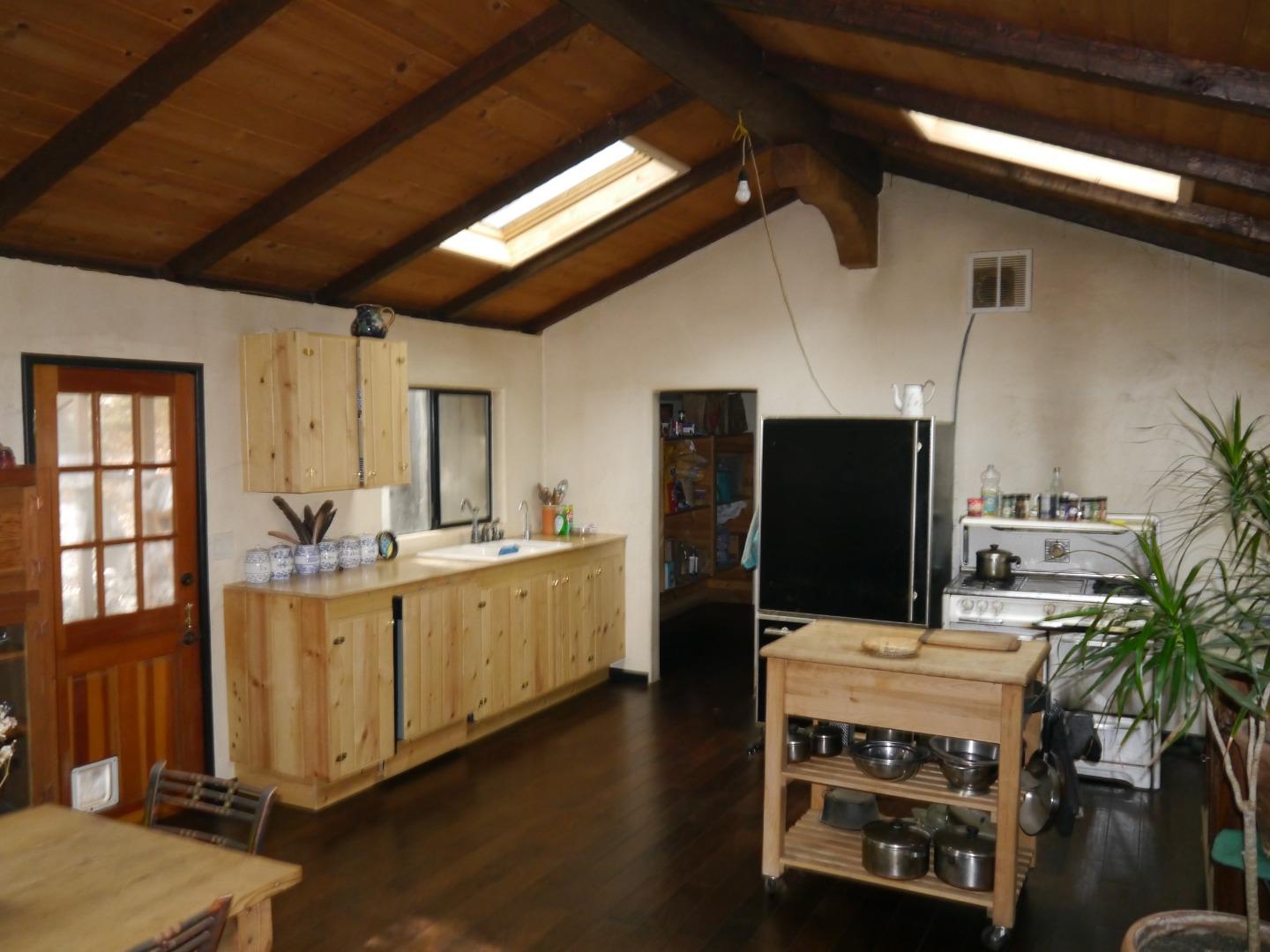 39450 Tassajara Road Carmel Valley, CA 93924 - Photo 9 of 61 a kitchen with stainless steel appliances kitchen island granite countertop a refrigerator a stove and a sink with wooden floor