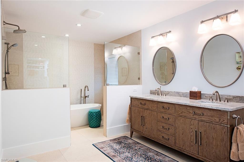 370 Rudder Road Naples, FL 34102 - Photo 11 of 26 a bathroom with a double vanity sink mirror and bathtub