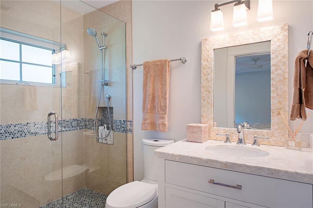 370 Rudder Road Naples, FL 34102 - Photo 13 of 26 a bathroom with a granite countertop sink toilet and shower
