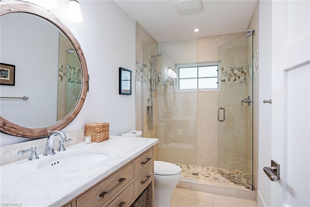 370 Rudder Road Naples, FL 34102 - Photo 15 of 26 a bathroom with a sink a toilet and shower