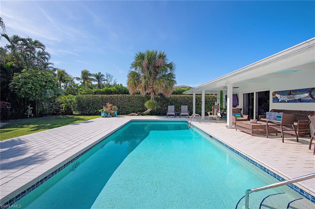 370 Rudder Road Naples, FL 34102 - Photo 18 of 26 a view of a house with swimming pool and sitting area