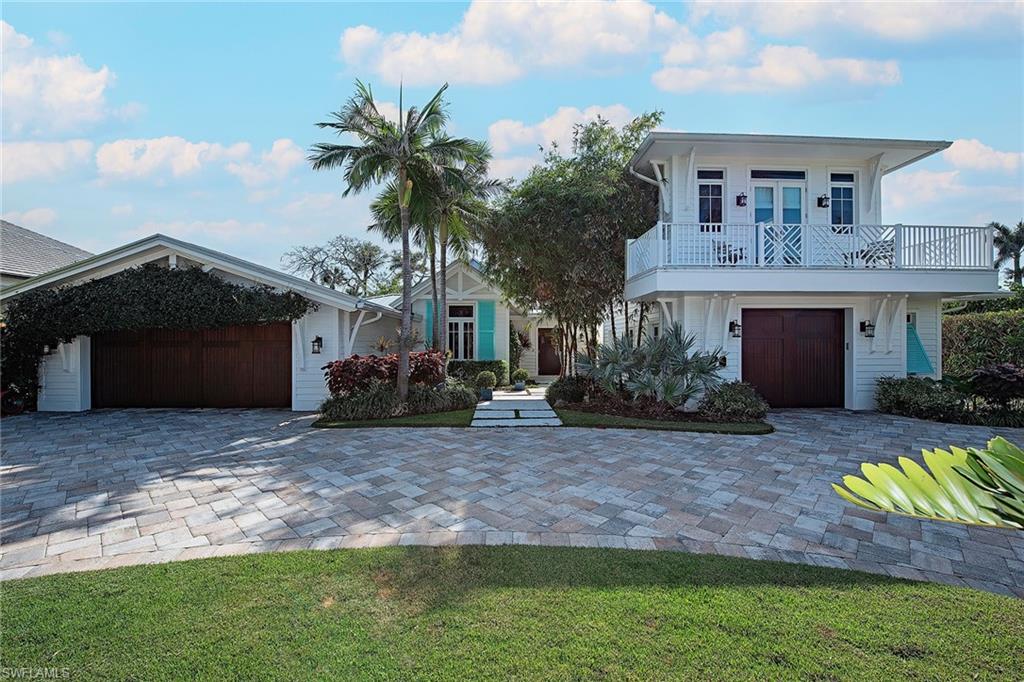 370 Rudder Road Naples, FL 34102 - Photo 2 of 26 a front view of a house with a yard and garage