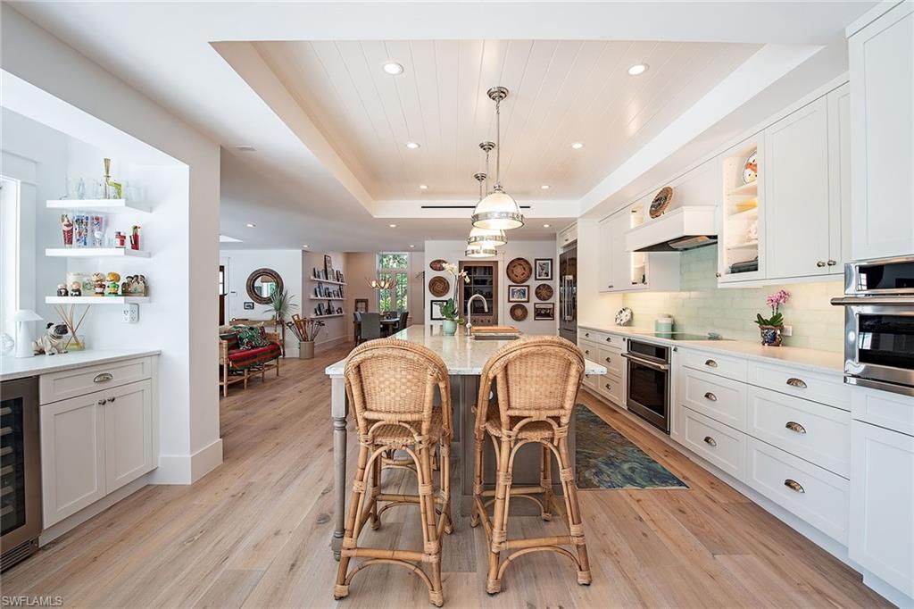 370 Rudder Road Naples, FL 34102 - Photo 9 of 26 a view of dining table chairs wooden floor and kitchen view