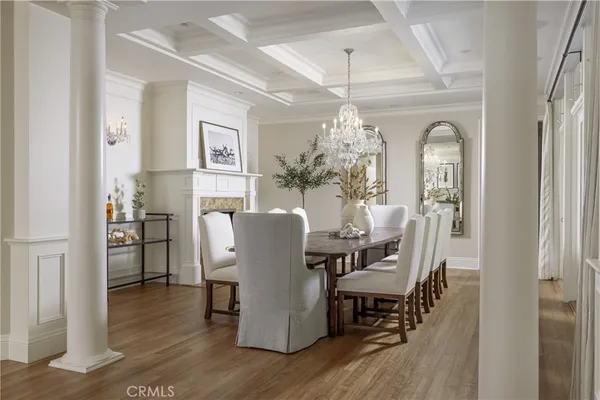 a dining room with furniture a chandelier and wooden floor