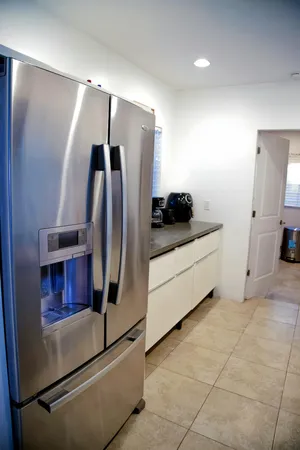 a kitchen with stainless steel appliances granite countertop a refrigerator and a sink