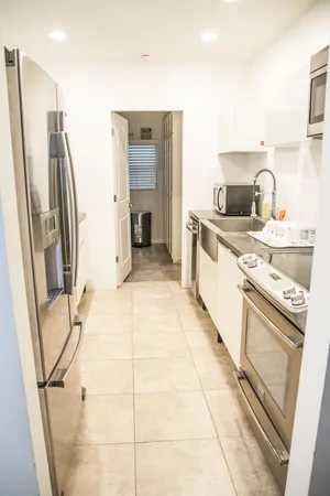 a kitchen with a sink a refrigerator and washer