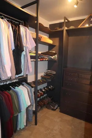 a view of walk in closet with clothes and shoes