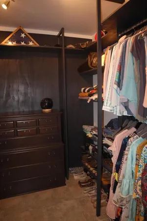 a view of walk in closet with clothes and shoes