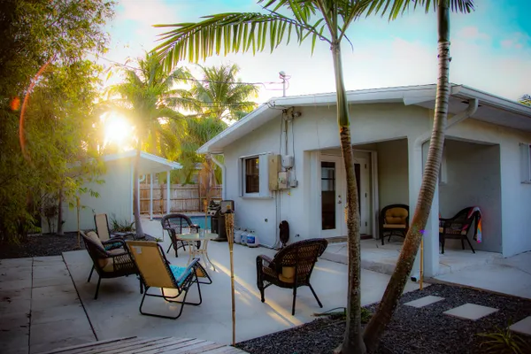 a backyard of a house with barbeque oven table and chairs