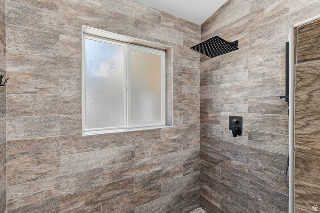 114 North Clark Lane Elk Ridge, UT 84651 - Photo 12 of 26 Shower enclosure featuring wood-grain tile walls, a frosted window, and matte black fixtures including a rain shower head and integrated controls