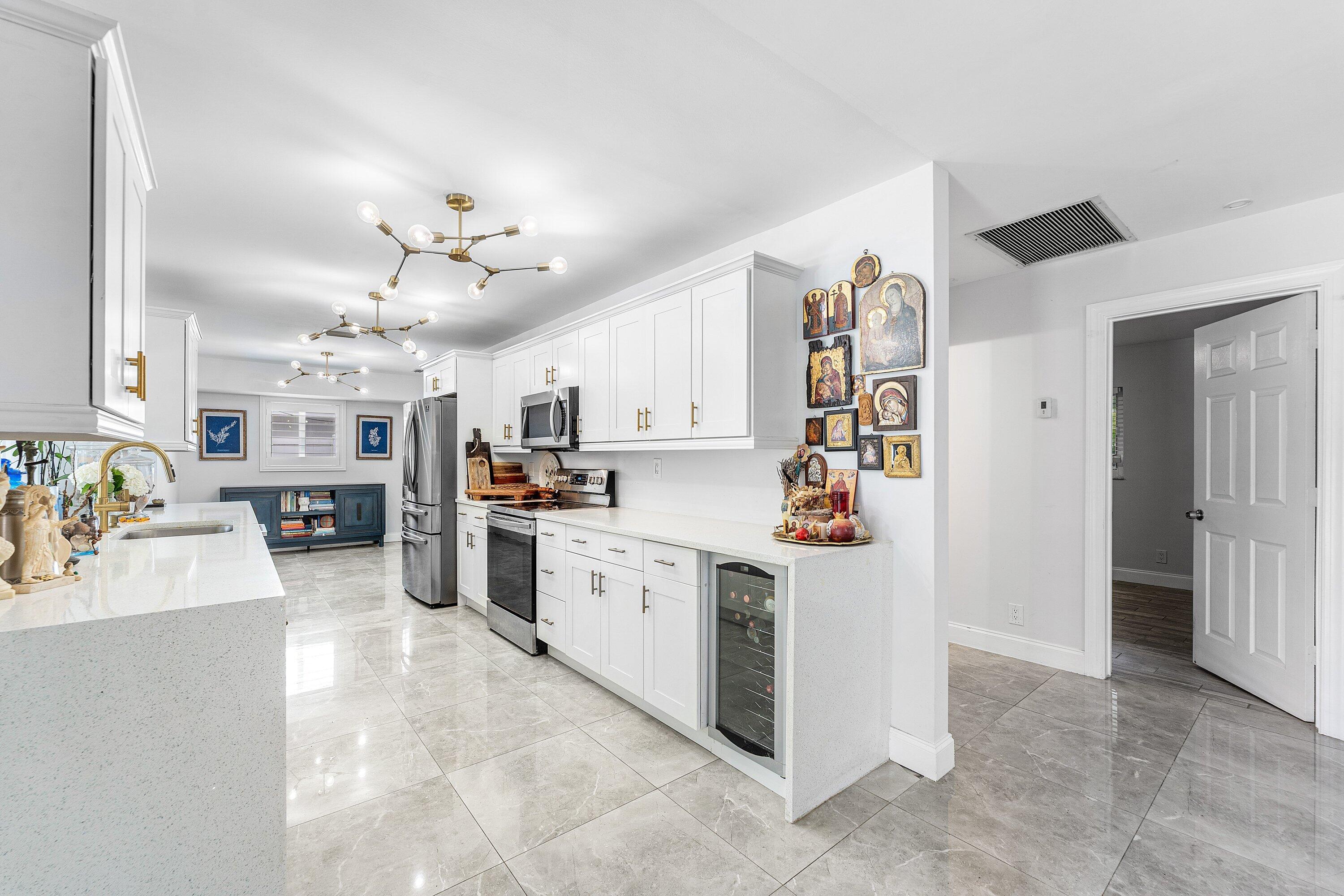 581 Northwest 13th Drive Boca Raton, FL 33486 - Photo 8 of 39 a kitchen with cabinets and wooden floor