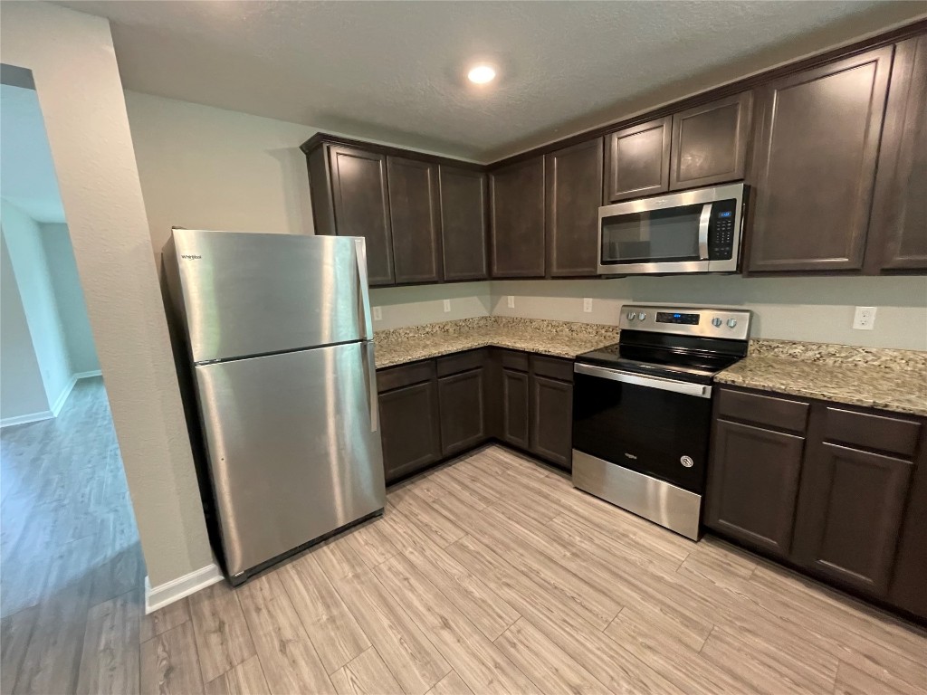77444 Lumber Creek Boulevard Yulee, FL 32097 - Photo 6 of 24 a kitchen with granite countertop wooden cabinets stainless steel appliances and a granite counter tops