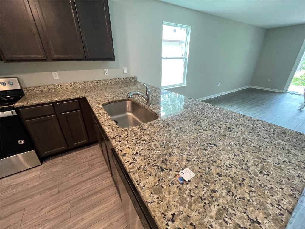 77444 Lumber Creek Boulevard Yulee, FL 32097 - Photo 7 of 24 a kitchen with granite countertop a sink and a wooden cabinets