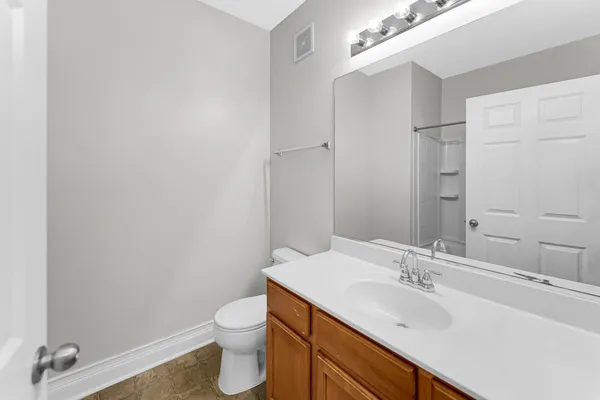 a bathroom with a toilet a sink a mirror and vanity