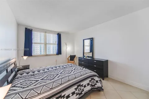 a bedroom with a bed and a dresser with mirror
