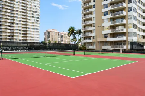 a view of a big building with a big yard and large trees