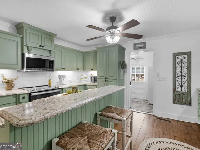 a kitchen with stainless steel appliances granite countertop a sink a stove top oven a counter space and cabinets