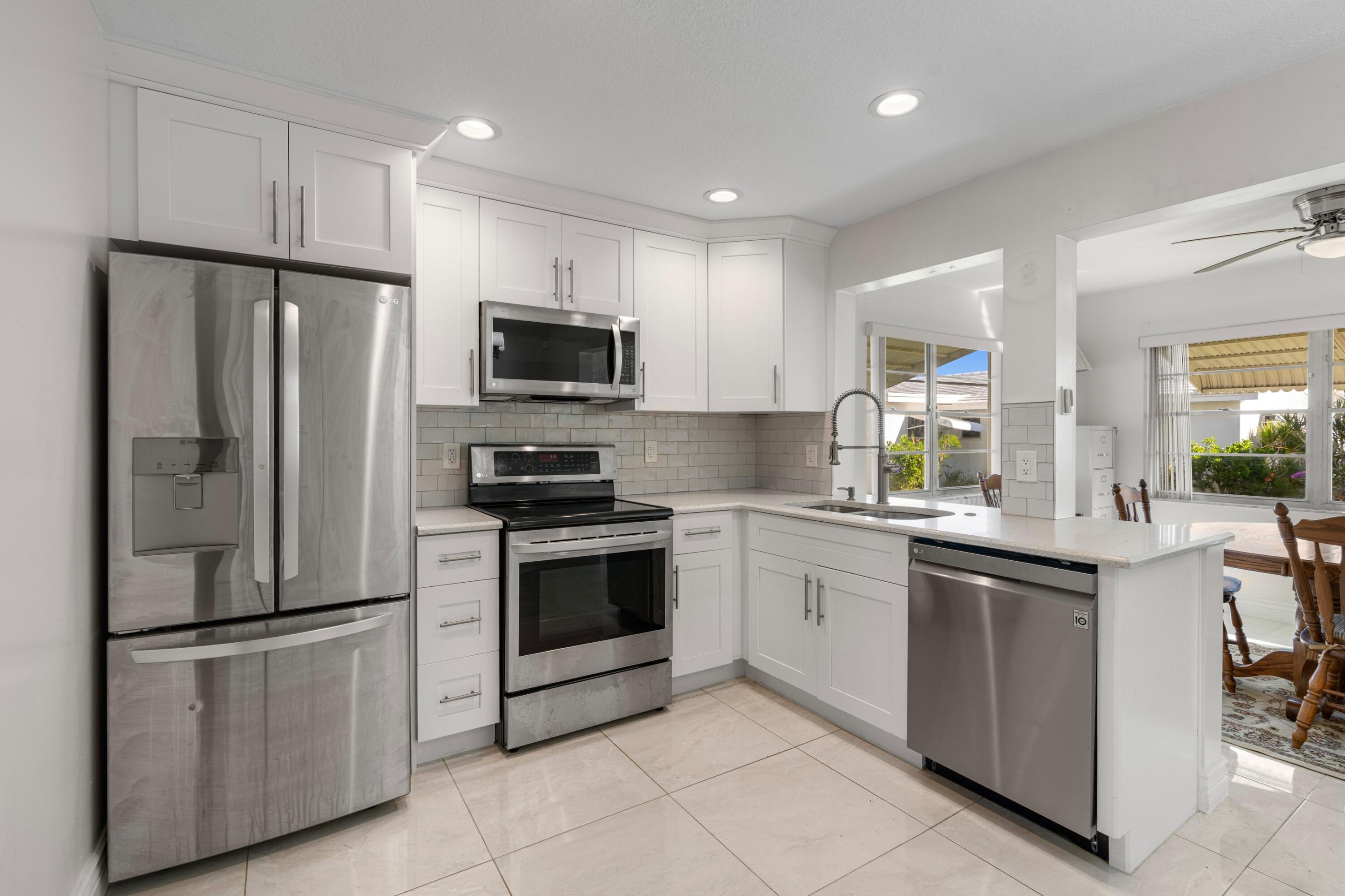 816 Southwest 18th Court Boynton Beach, FL 33426 - Photo 5 of 37 a kitchen with stainless steel appliances and white cabinets