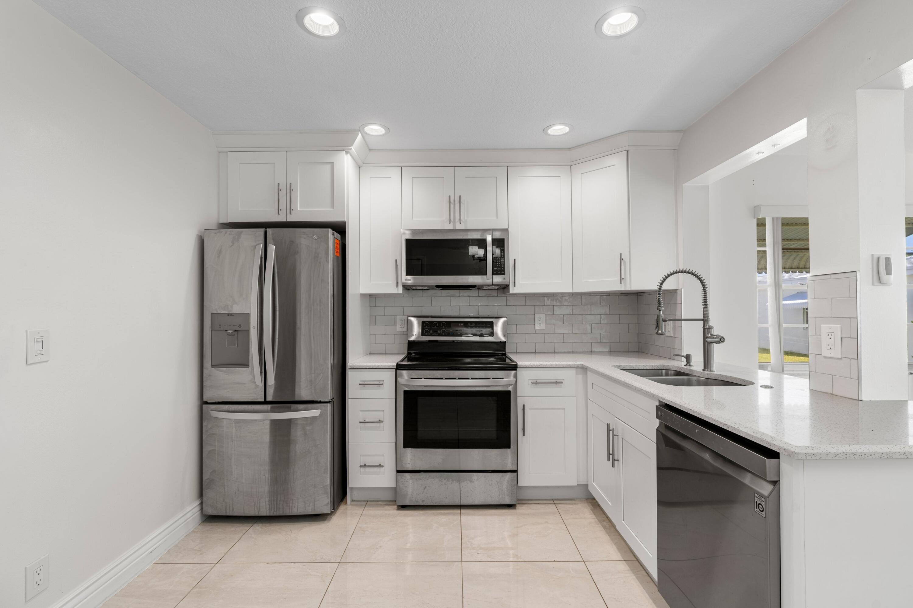 816 Southwest 18th Court Boynton Beach, FL 33426 - Photo 6 of 37 a kitchen with a sink stove and refrigerator