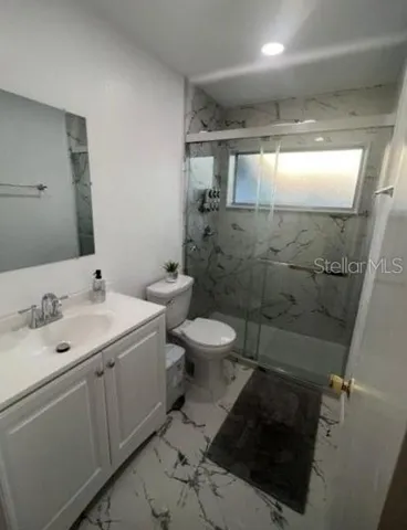 a view of an empty room with window and painting on the wall