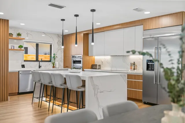 a large kitchen with kitchen island a large counter top a sink a stove and a wooden floors