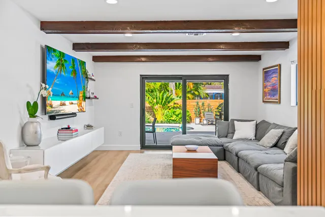 a living room with furniture and a floor to ceiling window