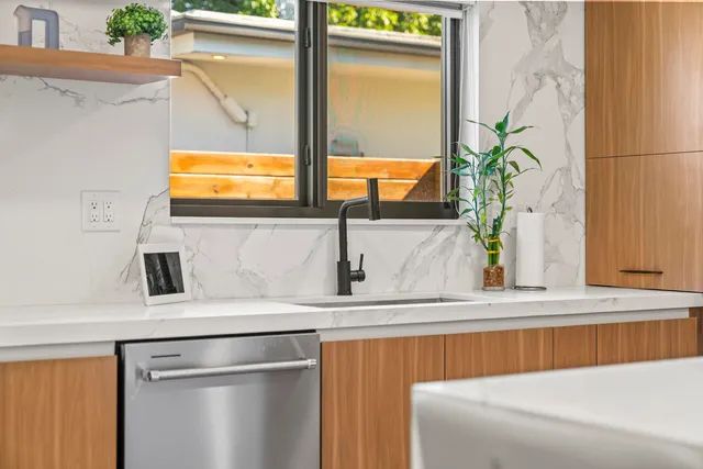 a kitchen with a table chairs wooden floors and a view of living room