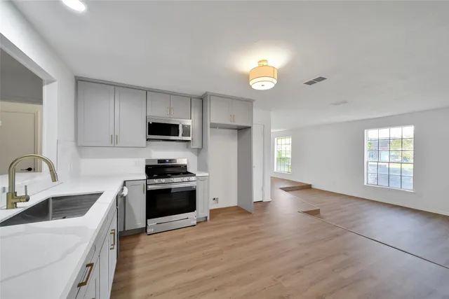 a kitchen with granite countertop a stove and a sink