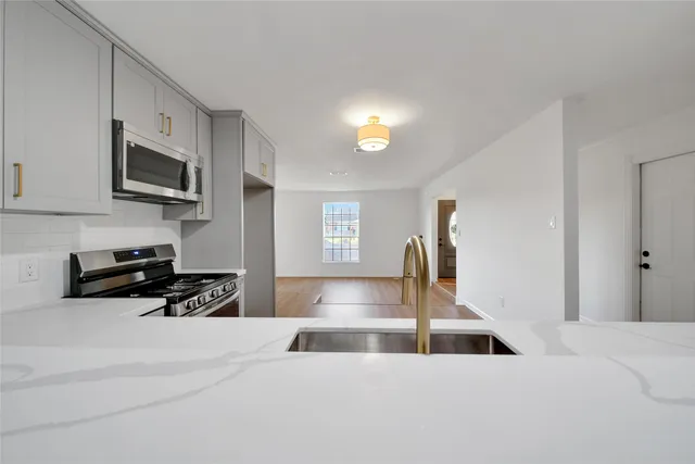 a kitchen with stainless steel appliances a sink a stove and cabinets