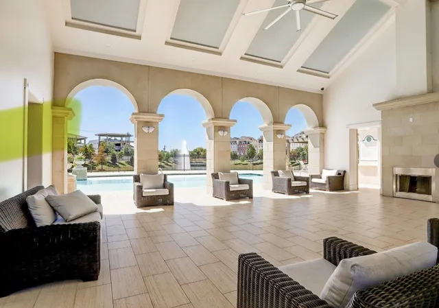 a living room with fireplace furniture and floor to ceiling window