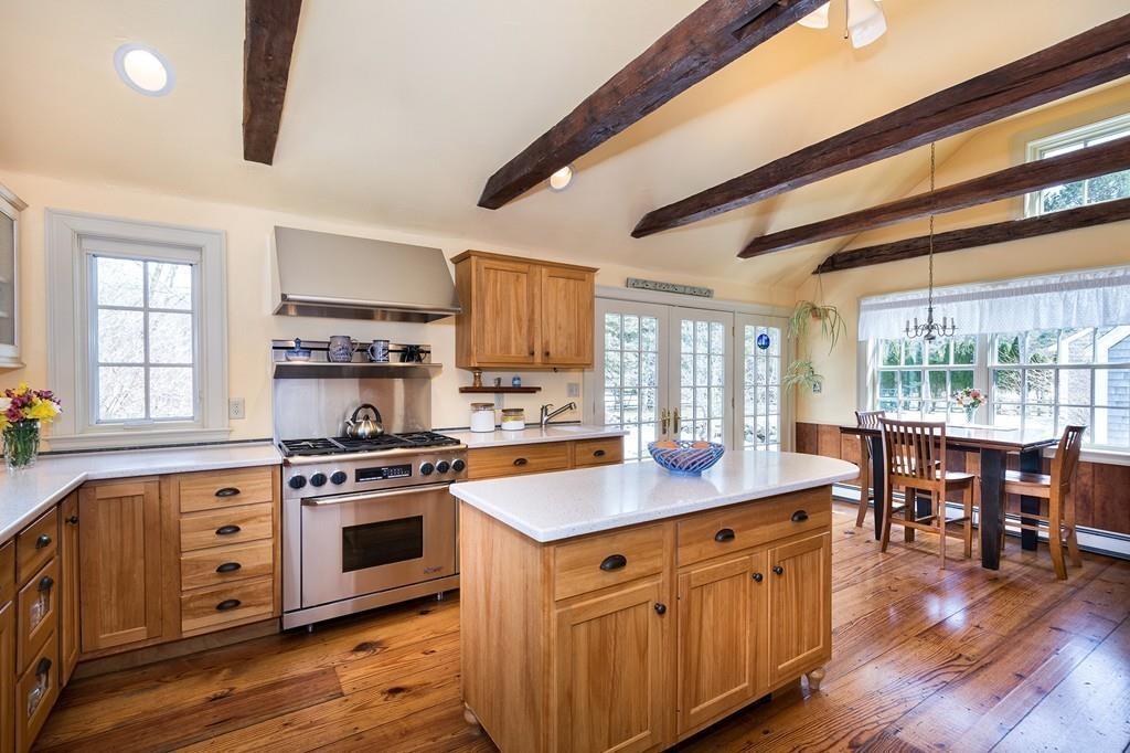 220 Prospect Street Hingham, MA 02043 - Photo 4 of 41 a kitchen with stainless steel appliances granite countertop a stove a sink dishwasher and a dining table with wooden floor