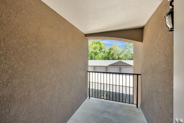 909 South Main Street, Unit G Layton, UT 84041 - Photo 16 of 25 Covered outdoor patio with a black metal railing, textured stucco walls, and a recessed ceiling light