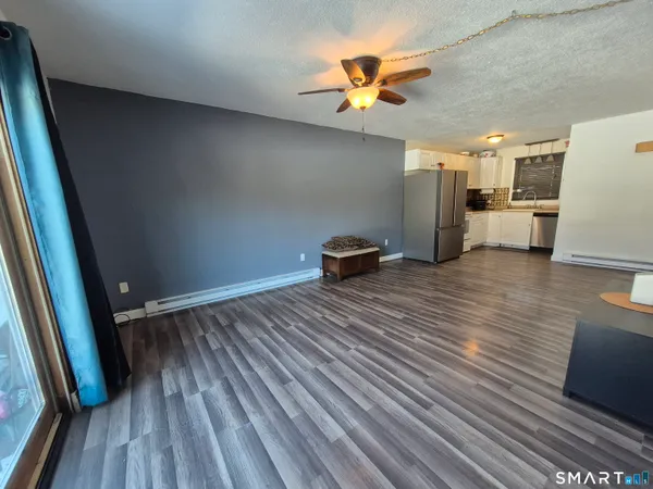 a view of a room with wooden floor and ceiling fan