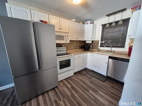 a kitchen with stainless steel appliances a refrigerator sink and cabinets