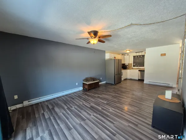 a view of a room with wooden floor and a ceiling fan