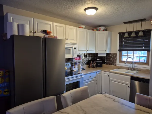 a kitchen with stainless steel appliances granite countertop a refrigerator sink and cabinets
