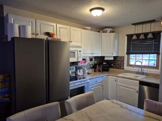 a kitchen with stainless steel appliances granite countertop a refrigerator sink and cabinets