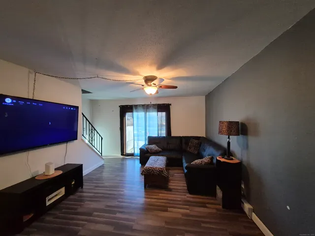 a living room with furniture and a ceiling fan