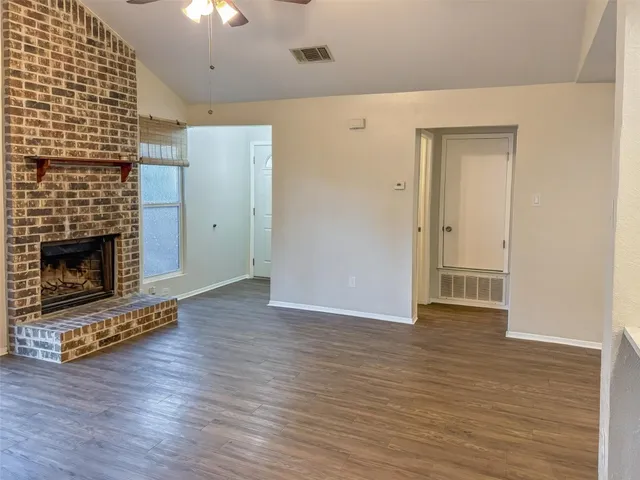a view of a livingroom with wooden floor and a fireplace