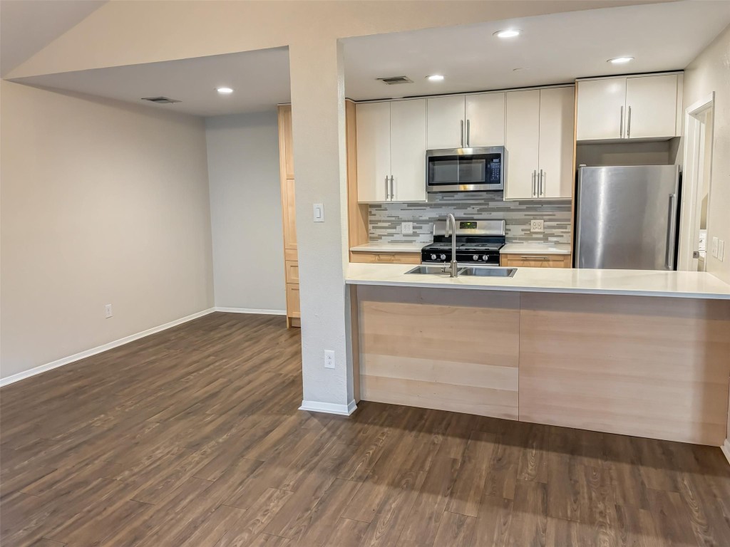 7006 Ivory Key Court, Unit A Austin, TX 78745 - Photo 4 of 16 a kitchen with a refrigerator and a microwave