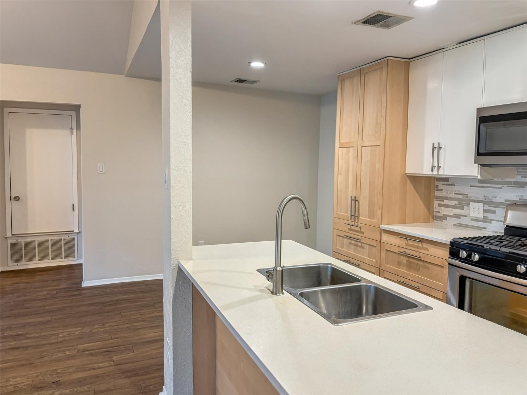 7006 Ivory Key Court, Unit A Austin, TX 78745 - Photo 6 of 16 a kitchen with stainless steel appliances granite countertop a sink a stove and a refrigerator with wooden floor