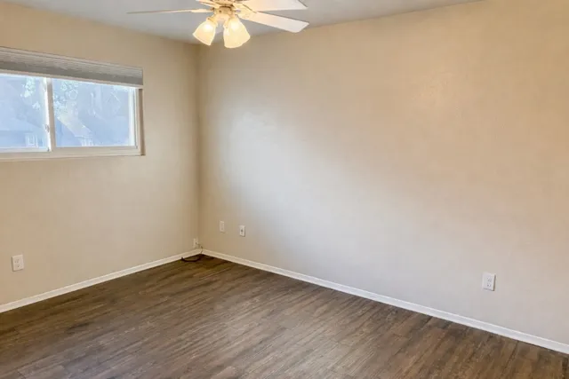 a view of a room with wooden floor and fan