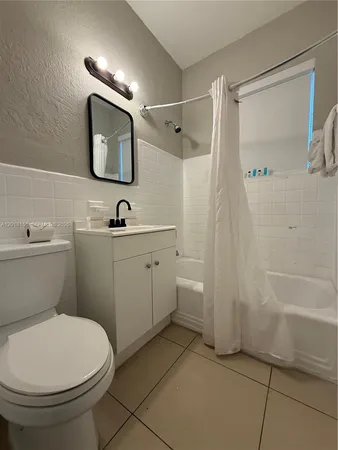 a bathroom with a sink a toilet and shower a mirror